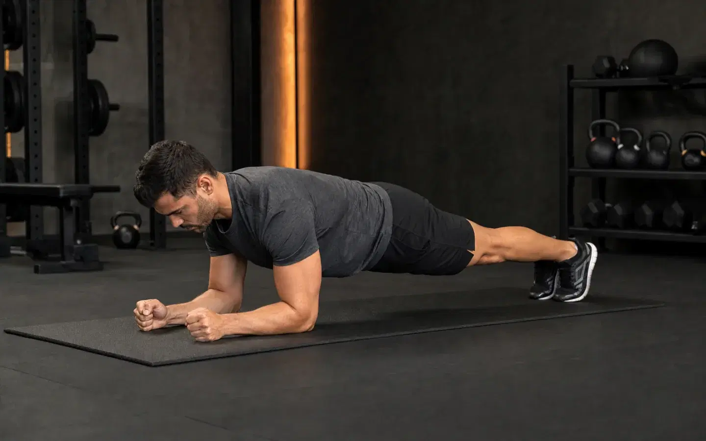 Athlete holding a forearm plank with elbows beneath the shoulders.