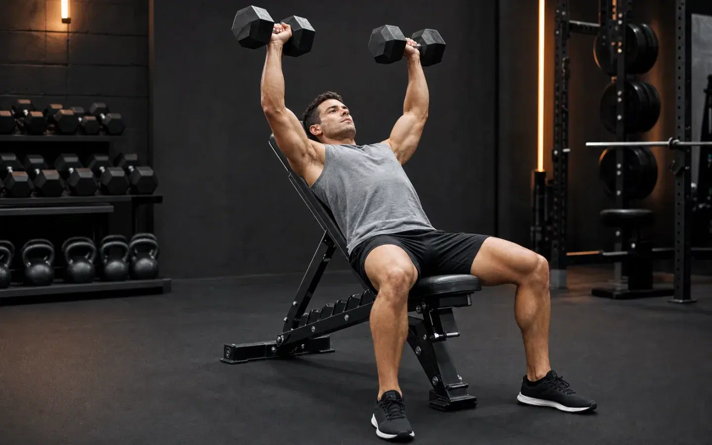 Athlete performing an incline dumbbell press with both feet planted.